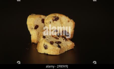 Pezzi di torta inglese con la frutta secca su sfondo nero. I tre pezzi dei dolci tipo muffin, chiamati anche torte di frutta. Il Foto Stock