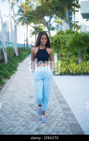 Ritratto di una giovane donna Africana americana che cammina casualmente all'esterno Foto Stock