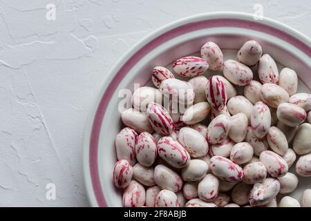 Fagioli borlotti di mirtillo rosso e bianco in ciotola con Finitura rosa Foto Stock