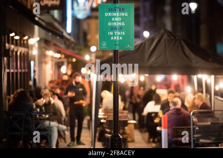Londra, Regno Unito. 13 aprile 2021. La gente si riunisce a Soho, Londra, dove le strade sono state chiuse al traffico mentre bar e ristoranti sono aperti per mangiare e bere all'aperto, poiché le misure di blocco sono facilitate in tutto il Regno Unito. Data immagine: Martedì 13 aprile 2021. Il credito fotografico dovrebbe essere: Matt Crossick/Empics/Alamy Live News Foto Stock