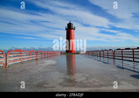 Il faro di Milwaukee Pier Head o il faro rosso si riflettono nel ghiaccio Contro il cielo blu Foto Stock