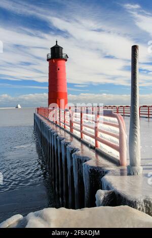 Faro di Milwaukee Pier Head o faro rosso contro Blue Sky Con molo coperto di ghiaccio Foto Stock