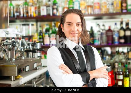 Giovane Barista o barman in piedi nella sua caffetteria o bar Foto Stock