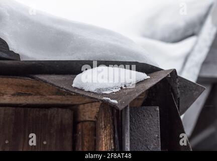 Vero e proprio strato spesso di neve sul vecchio tetto a nuvoloso giorno invernale Foto Stock