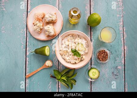 Preparazione di tzatziki mediterraneo con yogurt, cetriolo, menta e altri ingredienti Foto Stock