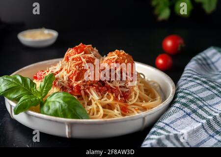 Deliziosa pasta di spaghetti con polpette, parmigiano e salsa di pomodoro, focalizzazione selettiva Foto Stock