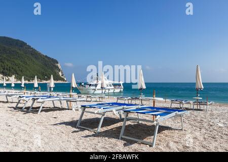 Sedie a sdraio vuote in attesa di turisti su una bellissima spiaggia Foto Stock