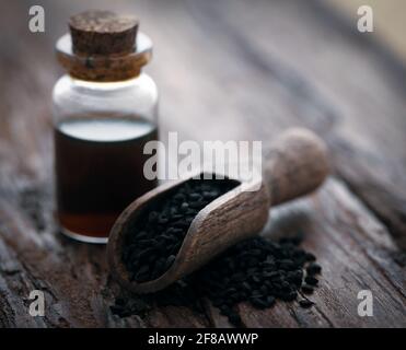 Nigella semi e olio essenziale in una bottiglia di vetro Foto Stock