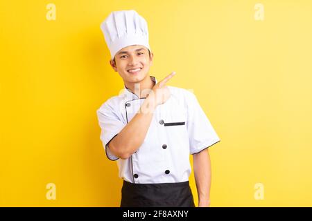 Immagine dello chef asiatico su sfondo giallo Foto Stock