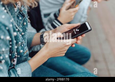 Podolsk, Ucraina - 29 marzo 2021: Donna che tiene smartphone con servizio sociale di Internet Tik Tok sullo schermo. Tiktok social network. Logo del CUR Foto Stock