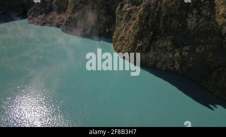 Volo sui laghi di Vulanice a bassa quota. Vista ravvicinata di un muro di roccia che separa i laghi colorati. Cratere vulcanico di Kelimutu tricolore coperto Foto Stock