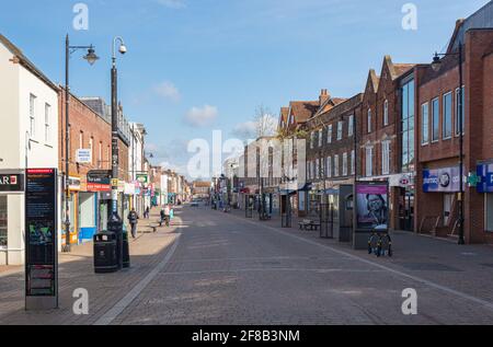 Newbury High Street con negozi e con pavimentazione in blocco rosso in una giornata di sole con nuvole di luce. Newbury, Berkshire, Inghilterra, Regno Unito. Preso l'11 aprile 2021. Foto Stock