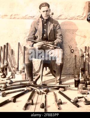 L'ufficiale della polizia si pone con tubi di oppio, lampade e altri paraphernalia confiscati alle incursioni di Opium den a San Francisco all'inizio del 1900 Foto Stock
