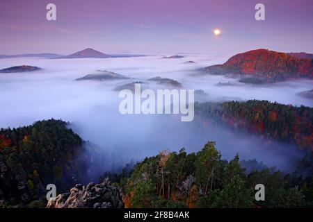 Misty notte paesaggio con la luna. Paesaggio ceco d'autunno. Colline e villaggi con mattina nebbia. Mattina Valle d'autunno del parco della Svizzera Boemia, Cesk Foto Stock