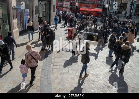 Nel giorno in cui il governo britannico ha facilitato le restrizioni di Covid per consentire ad aziende non essenziali come negozi, pub, bar, palestre e parrucchieri di riaprire, folle di acquirenti attraversano Oxford Circus, il 12 aprile 2021, a Londra, Inghilterra. Foto Stock