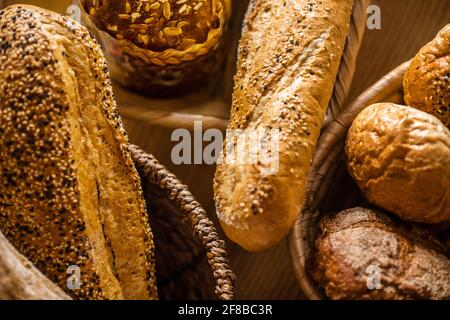 Baguette fresche e pani di pane sdraiati sul tavolo Foto Stock