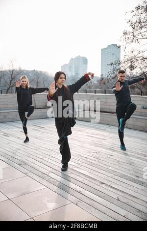 Tai chi fuori sul tetto durante l'esercizio su una gamba Foto Stock