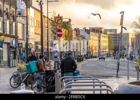 Cardiff, Galles, Regno Unito - 12 aprile 2021: Vista generale dei ciclisti Deliveroo delivery su Duke Street, questa sera. Foto Stock