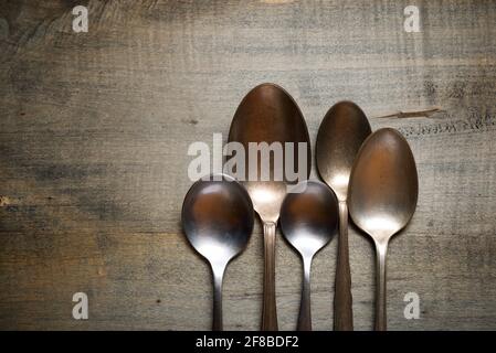 Raccolta di cucchiai su un tavolo di legno. Foto Stock