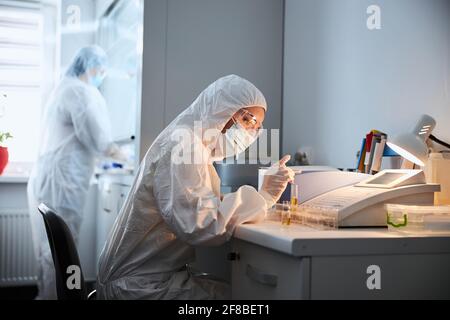 Due virologi che eseguono test chimici in un laboratorio di ricerca Foto Stock