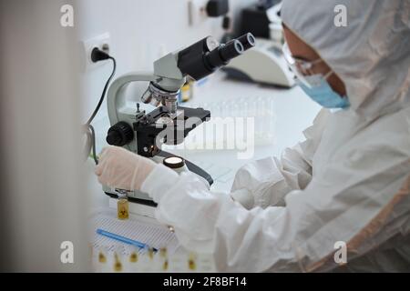 Virologo femminile che esamina un nuovo farmaco antivirale Foto Stock