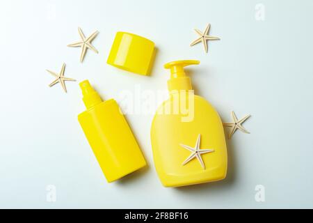 Bottiglie di crema solare e di Starfises su sfondo bianco Foto Stock