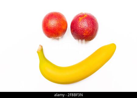 Banana sorridente e divertente arancio rosso isolato su sfondo bianco. Foto Stock