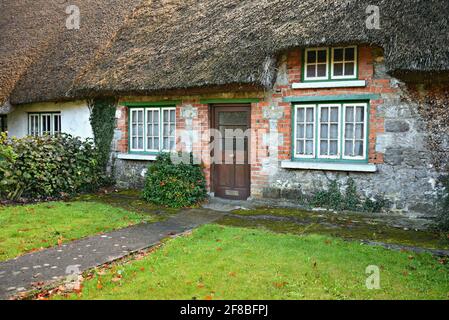 Originale cottage del 19 ° secolo tetto di paglia nel pittoresco villaggio di Adare nella contea di Limerick Irlanda. Foto Stock