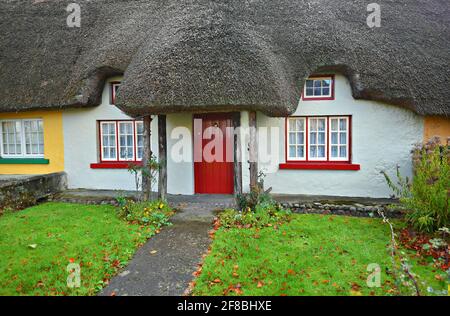 Originale cottage del 19 ° secolo tetto di paglia nel pittoresco villaggio di Adare nella contea di Limerick Irlanda. Foto Stock