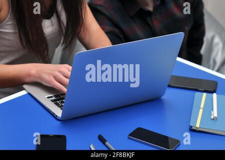 Programmatore, Mobile Application Designers, Web Designer che lavora in ufficio. Lavoro di squadra e programmazione di siti web e applicazioni mobili sul laptop. Foto Stock