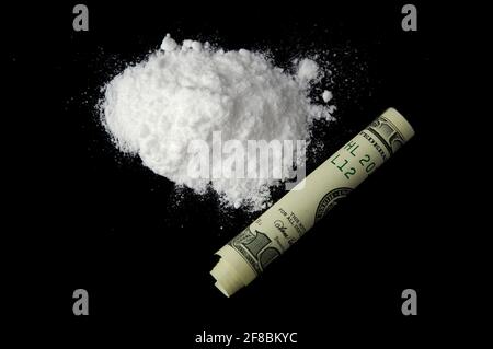 Mucchio di cocaina e denaro isolato su uno sfondo nero. Tossicodipendente. Concetto di attività criminale. Foto Stock