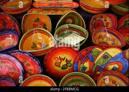 Piatti da insalata dipinti a mano con una selezione colorata di disegni per la vendita su un mercato francese stand. Foto Stock