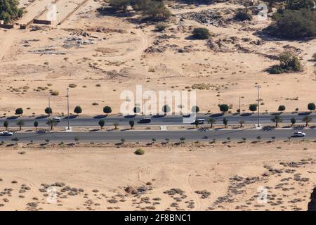 Tipica strada in Arabia Saudita che conduce attraverso un villaggio nel deserto Foto Stock