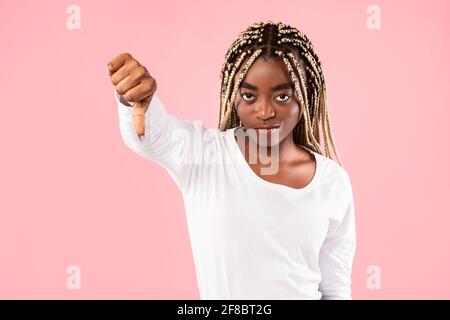 Donna afroamericana che mostra i pollici verso il basso segno gesto Foto Stock