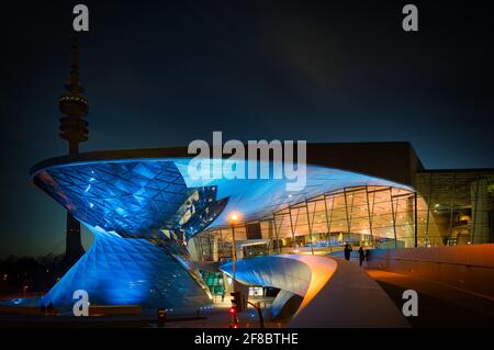 MONACO, GERMANIA - 25 febbraio 2021: BMW World Monaco di notte con la Torre Olimpica Foto Stock