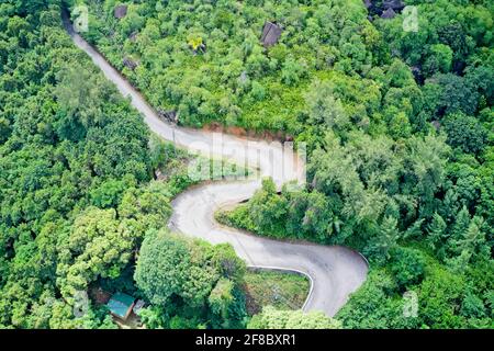 Drone campo di vista di una strada che si snoda attraverso un paesaggio verde che mostra modelli nella natura Mahé, Seychelles. Foto Stock