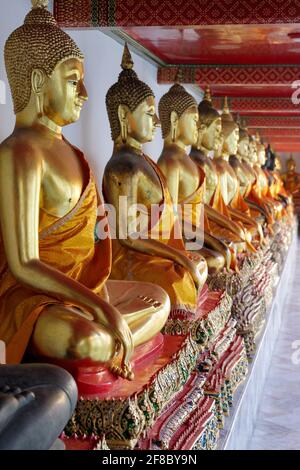 Linea di statue dorate di Buddha a Wat Pho, o Wat Phra Chetuphon a Bangkok, Thailandia Foto Stock