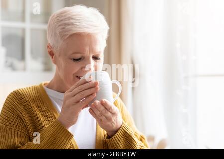 Primo piano di una donna anziana che beve caffè o tè Foto Stock