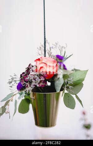 Una piccola pentola d'oro è piena di fiori da sposa all'aperto reception Foto Stock