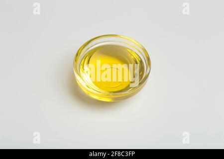 L'olio vegetale viene isolato in un recipiente di vetro. Olio vegetale liquido giallo su fondo bianco. Foto di alta qualità Foto Stock