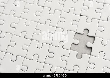 Bianco jigsaw puzzle pattern sfondo. Posizionamento ultimo pezzo di puzzle jigsaw Foto Stock