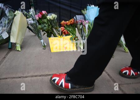 Fiori e messaggi lasciati da membri del pubblico fuori Buckingham Palace, Londra, dopo la morte del duca di Edimburgo all'età di 99 anni il venerdì. Data immagine: Martedì 13 aprile 2021. Foto Stock