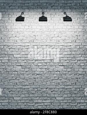 parete di mattoni bianchi con tre faretti Foto Stock