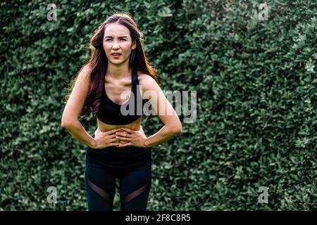 Sport giovane donna con il dolore al ventre. Il problema della salute concetto. Foto Stock