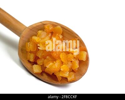 Buccia d'arancia candita su un cucchiaio di legno contro un bianco sfondo Foto Stock