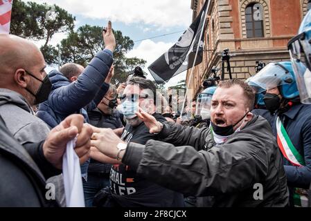 Roma, Italia. 13 Aprile 2021. I manifestanti si confrontano con agenti di polizia anti-sommari durante una dimostrazione di proprietari di ristoranti e lavoratori, imprenditori e proprietari di piccole imprese il 13 aprile 2021 al Circo massimo di Roma. Centinaia di manifestanti si sono riuniti a Circo massimo chiedendo la ripresa delle attività costrette a fermarsi a causa delle restrizioni del Covid-19. Credit: LSF Photo/Alamy Live News Foto Stock