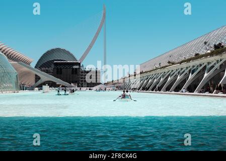 Persone che si godono le barche sul lago artificiale di fronte al Palau de les Arts nella Città delle Arti e delle Scienze, Valencia, Spagna. Foto Stock