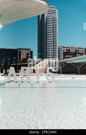 Arts segno fuori del Palau de les Arts Reina Sofia, Valencia Spagna, con vista sul lago artificiale, con edifici sullo sfondo e cielo perfetto. Foto Stock