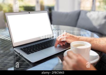 Uomo con computer portatile sulla scrivania che lavora nel bar o. ufficio con schermo vuoto Foto Stock