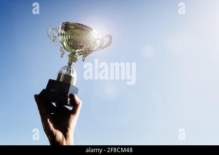 Celebrando con trophy award per il successo o il primo posto del campionato sportivo win Foto Stock